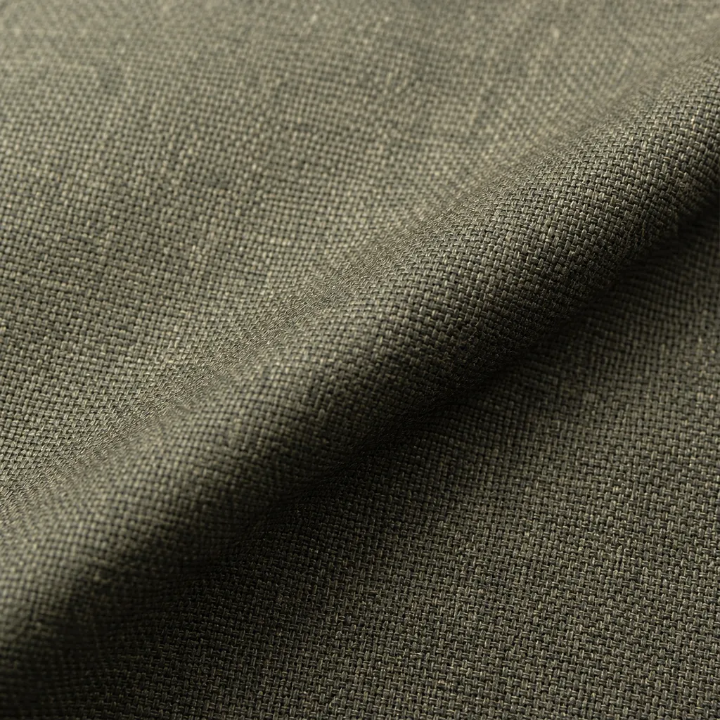 Macro photograph of high-twist worsted cloth, the tight open weave and subtle olive-grey melange filling the frame with visible texture.